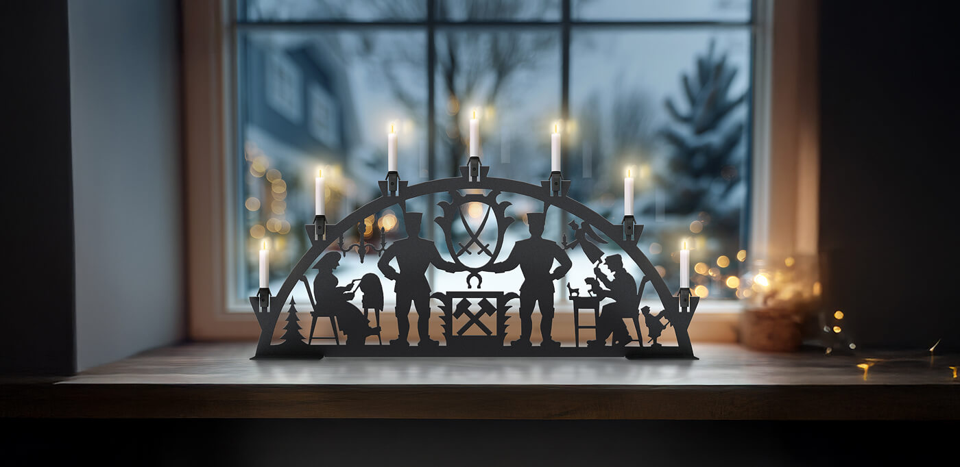 KNOBLOCH Schwibbogen auf einer Fensterbank mit Lichterkette und Bergmann Motiv